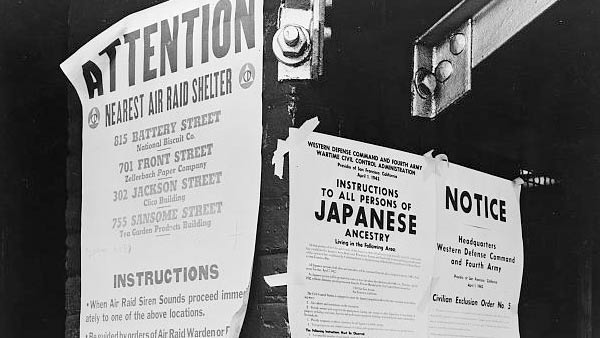black and white photo of posters displayed on a street corner
