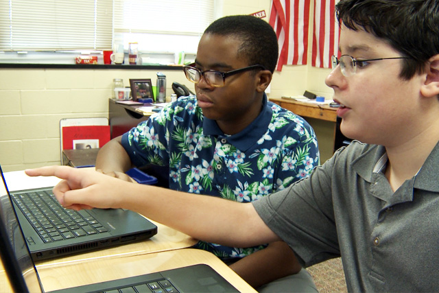 – two students working together on a laptop