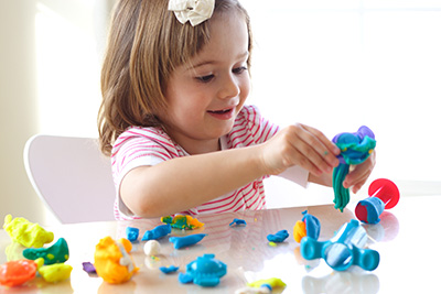 – young girl playing with playdough