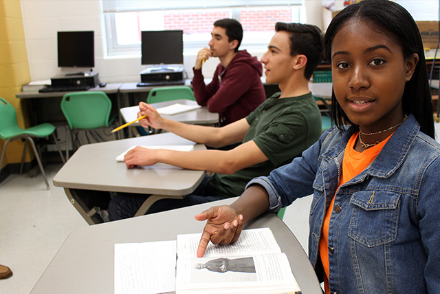 Jasmine in class pointing at the book