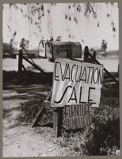 black and white photo of mailboxes with a sign that says 'evacuation sale'