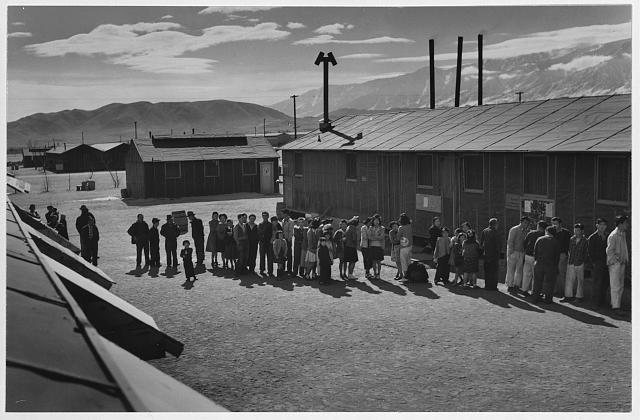 black and white photo of a line of people at a Japeanese internment camp