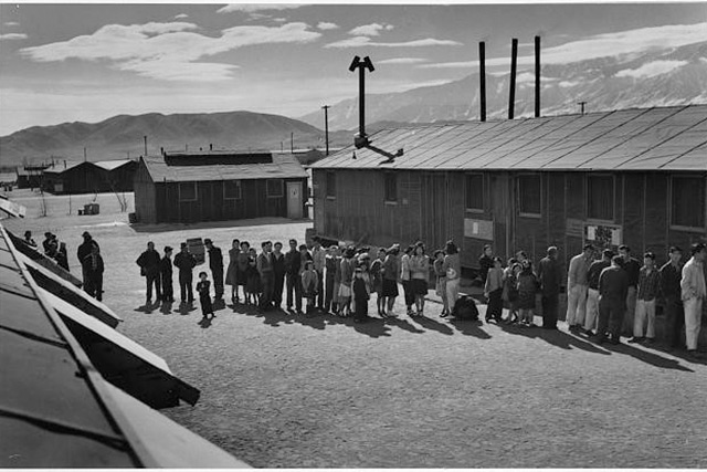 black and white photo of a line of people at a Japeanese internment camp